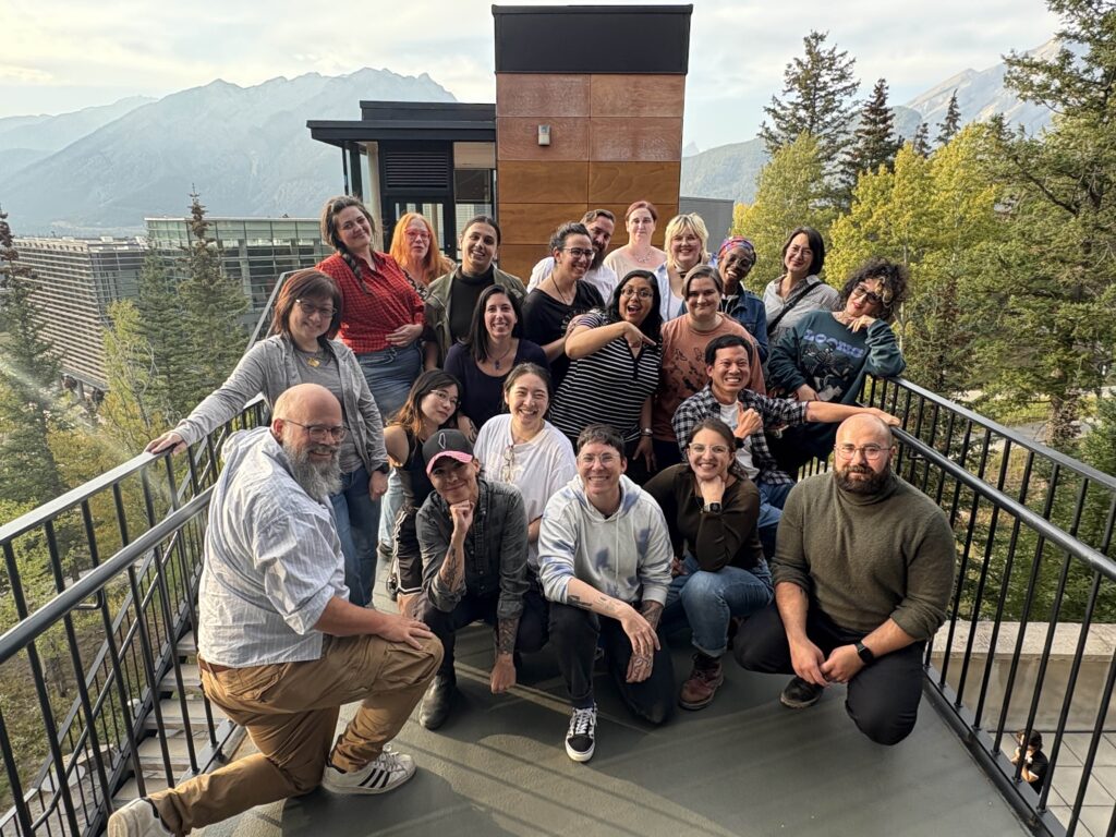 A bunch of people posing on a catwalk in front of a mountain view